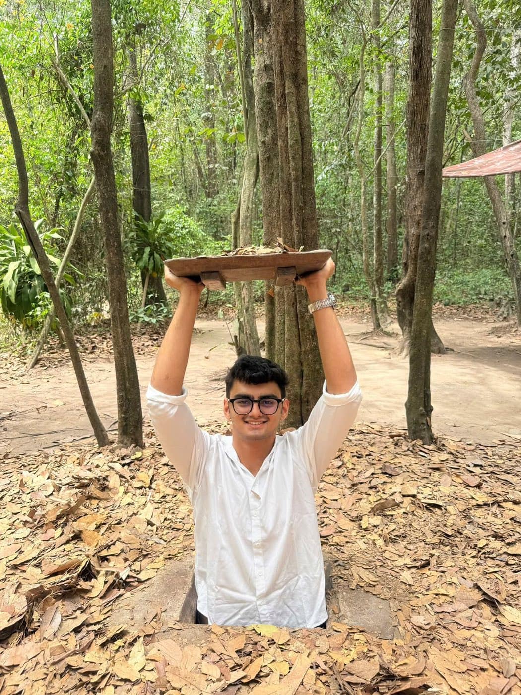 A guest standing in a tunnel hatch with the wooden lid held above his head