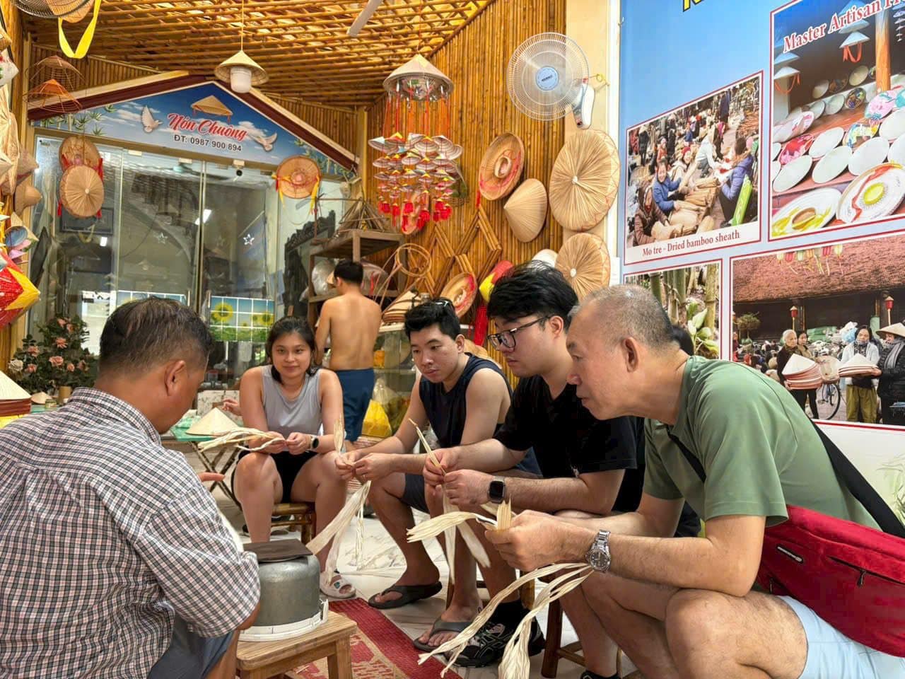 Guests sitting with a stallholder, learning what she is making