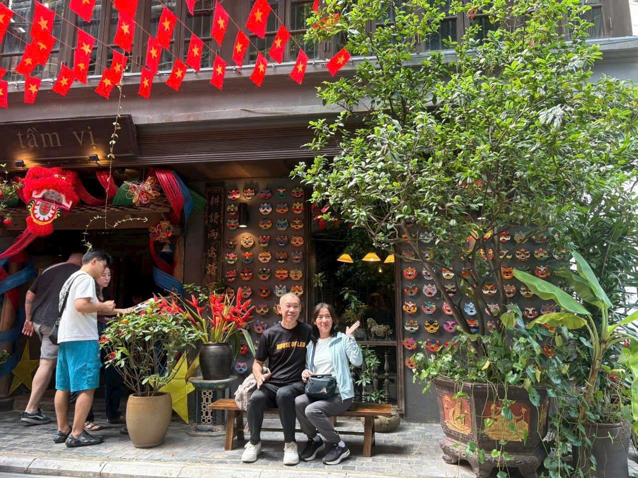 A lantern-hung shopfront in the Old Quarter with a lion dance head at the door