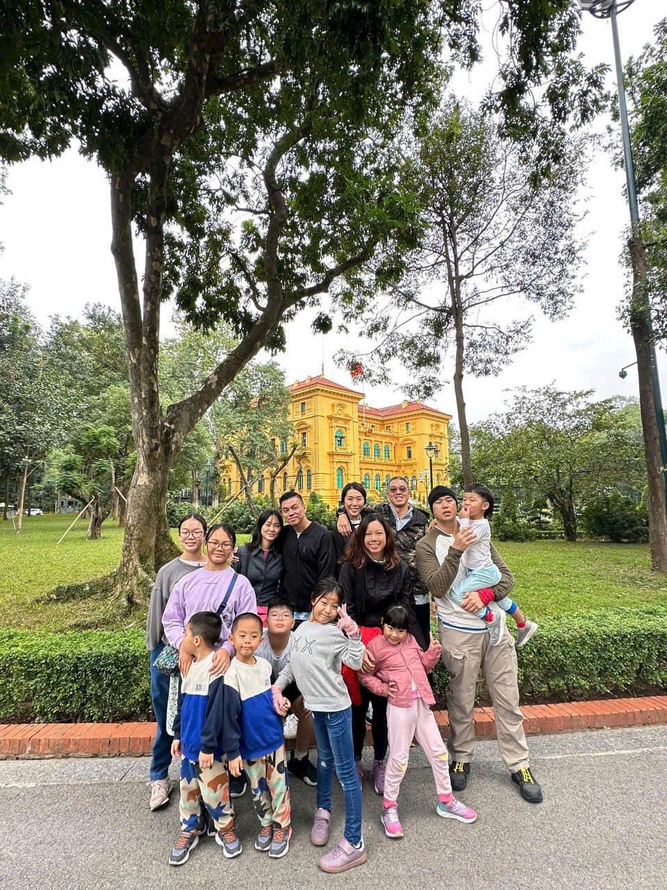 A family group on the tree-lined avenue beside the ochre Presidential Palace