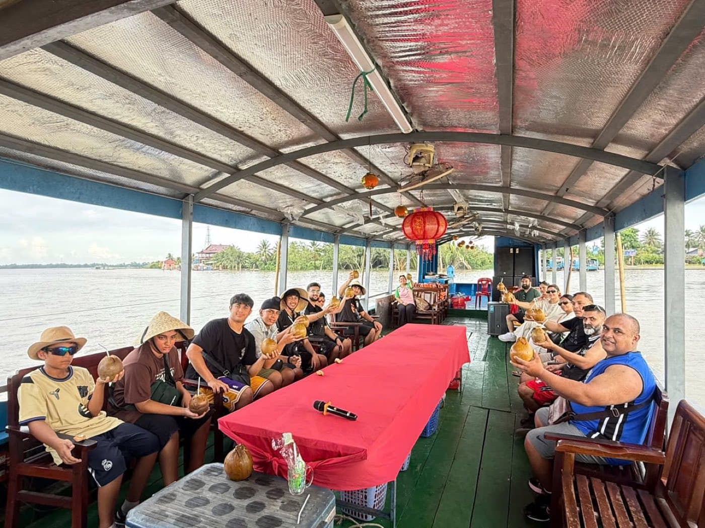 The group down both sides of the long red table on the covered river boat