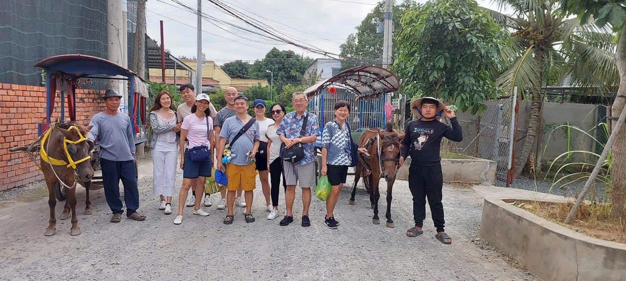 A group meeting the horses on a village road in the delta