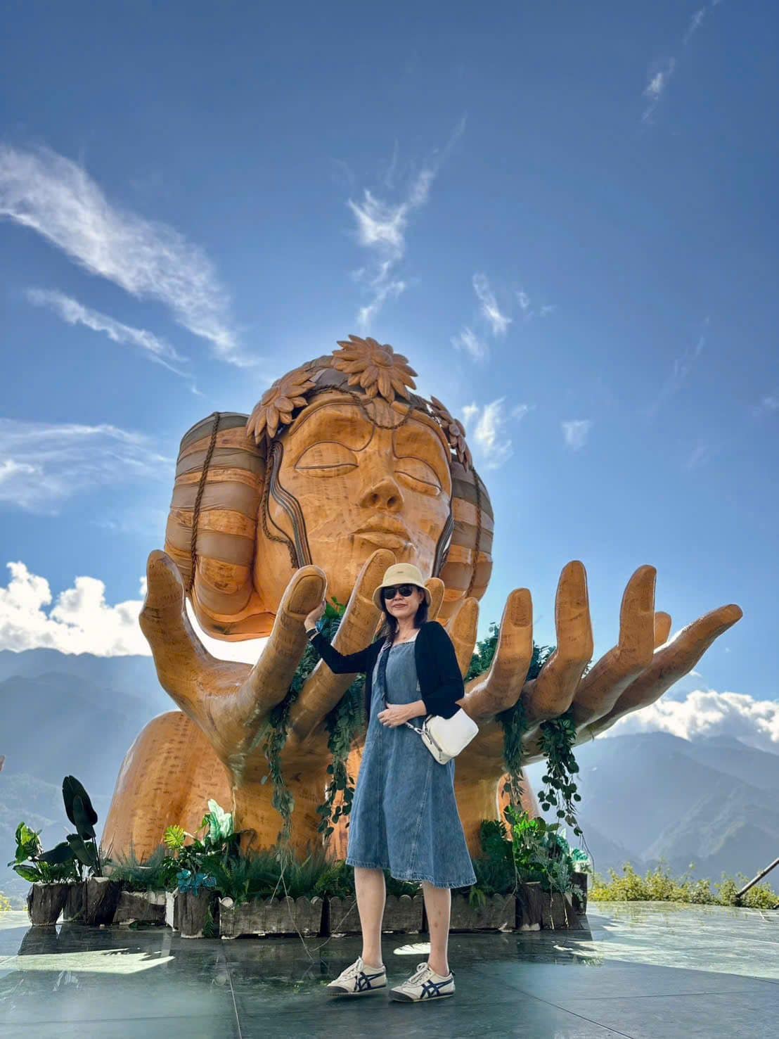 A guest in the hand sculpture above the cloud line in the northern mountains