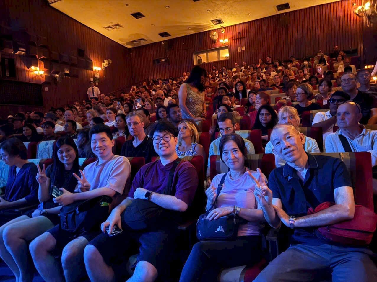 A full house at the water puppet theatre, lit blue from the stage
