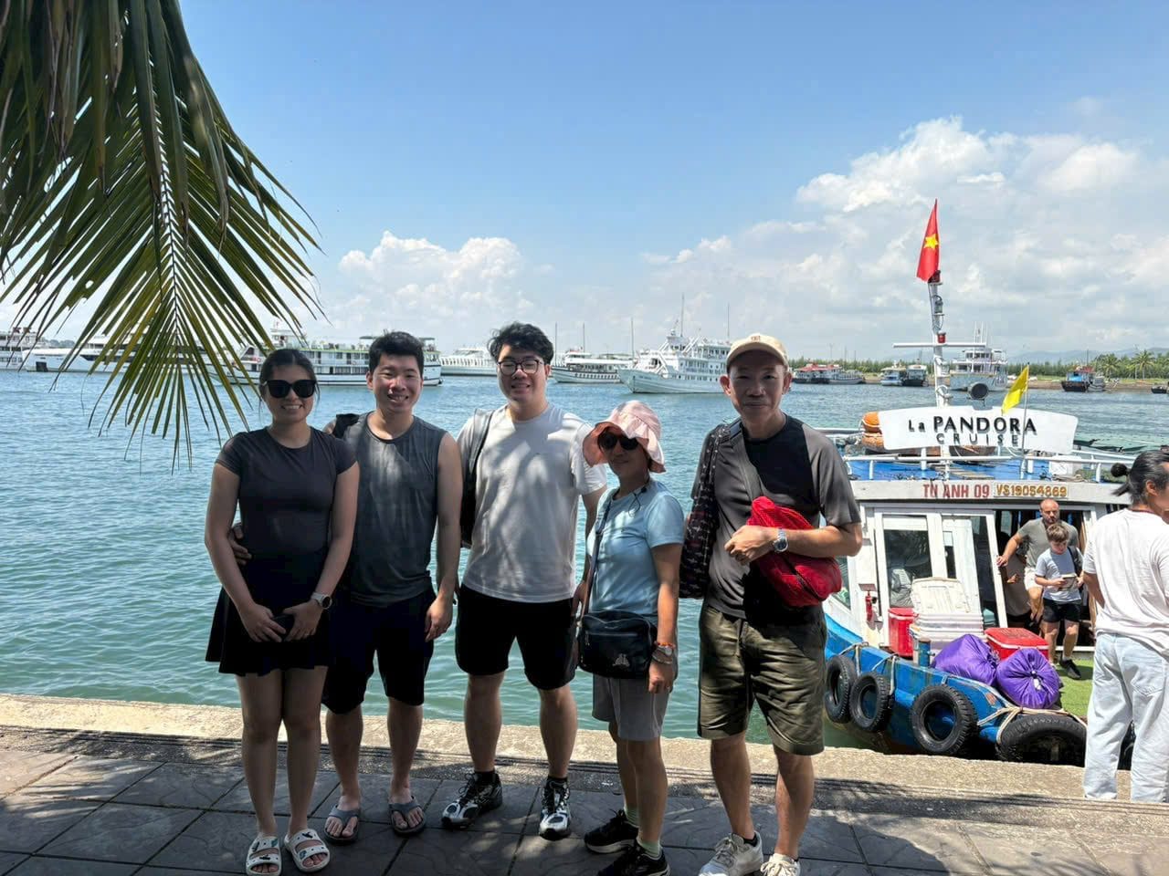 Four travellers at the harbour with the day boats behind them
