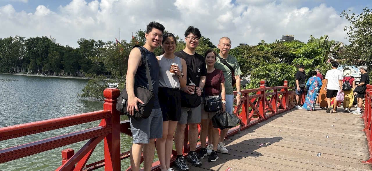 Guests on the red Huc bridge across to Ngoc Son Temple