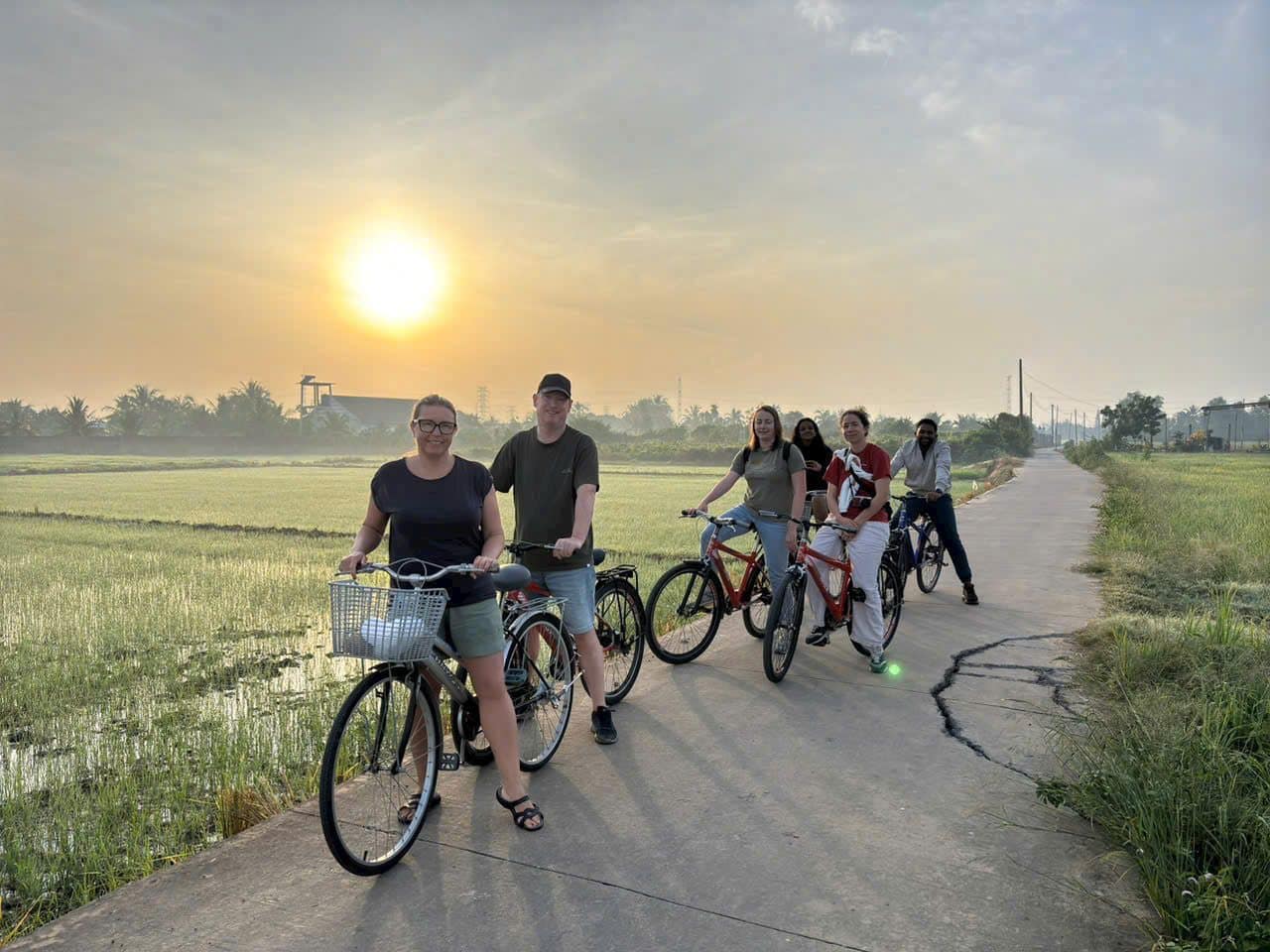 Cyclists strung out along a country road as the sun comes up