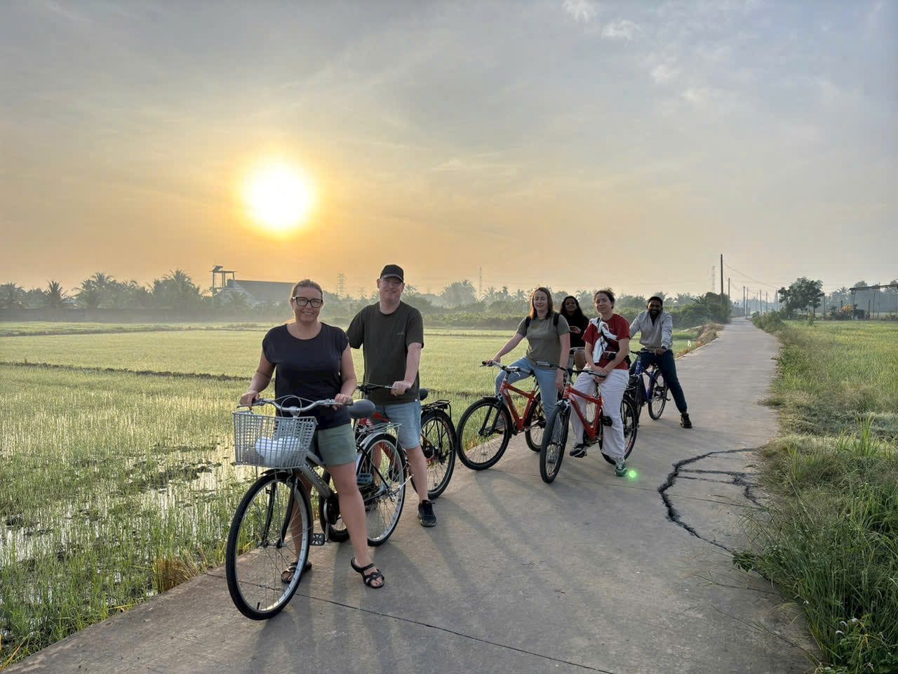 Cyclists strung out along a country road as the sun comes up
