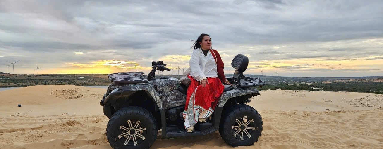 A guest on a quad bike out on the sand dunes at sunset