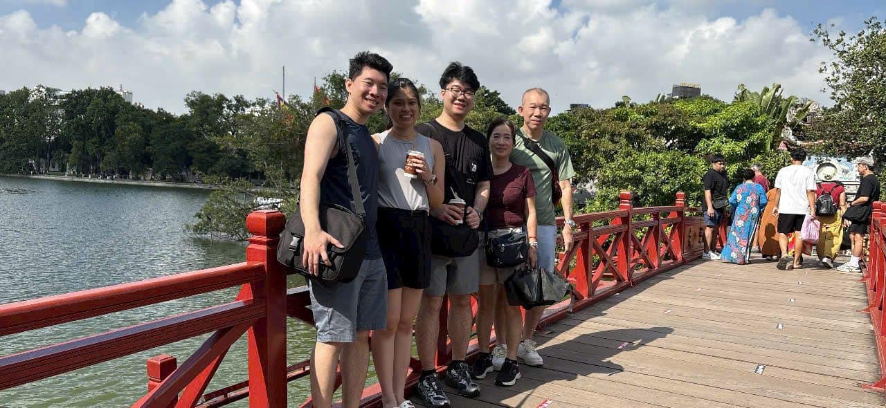 Guests on the red Huc bridge across to Ngoc Son Temple