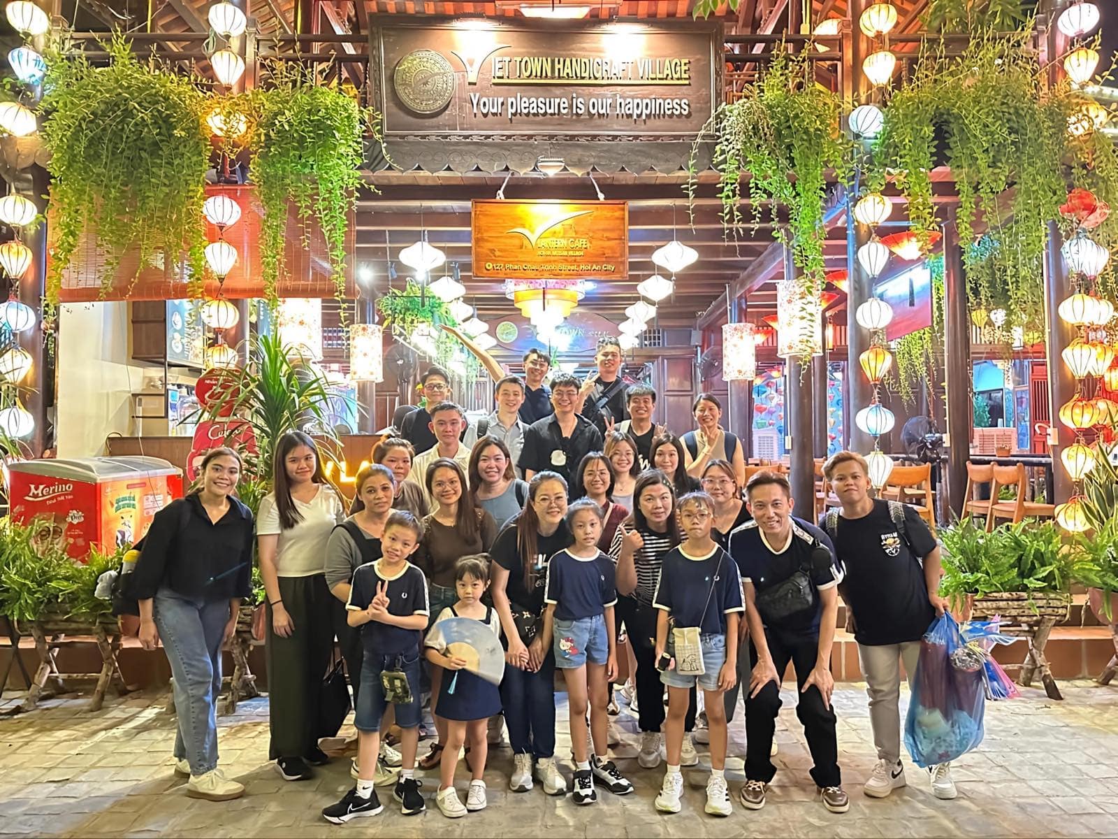 A tour group under the silk lanterns at the Viet Town Handicraft Village in Hoi An, lit for the evening